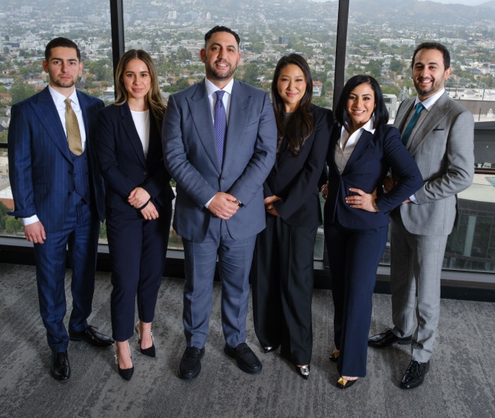 a group photo of the CAP law team standing in front of a window